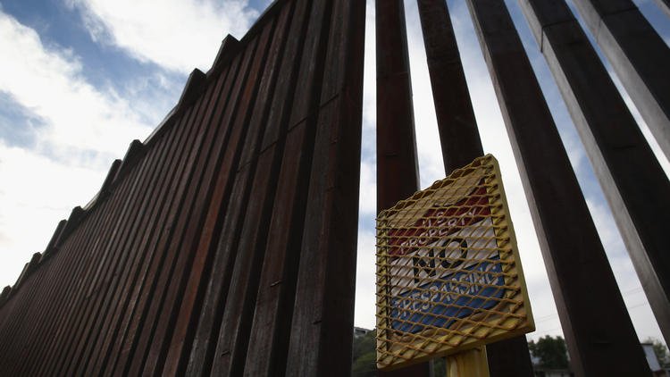 A border fence cuts through the desert that separates Nogales, Ariz., from Mexico. A new report says migration from Mexico has dropped while more Mexican in the U.S. have returned to their homeland. (John Moore / Getty Images)